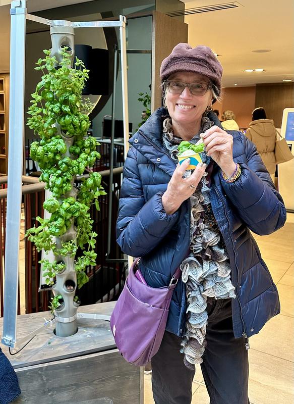 A person holding a fresh drink beside a growing tower